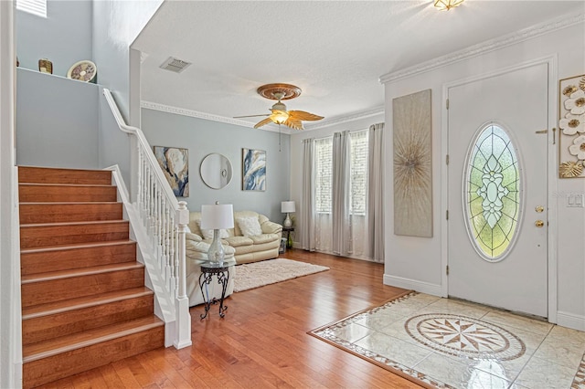 4604 Barbados Loop, Clermont, FL 34711 - foyer entrance featuring healthy amount of natural light, stairs, wood finished floors, ceiling fan, and ornamental molding