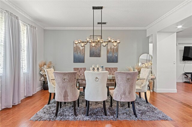 4604 Barbados Loop, Clermont, FL 34711 - dining room featuring wood finished floors, crown molding, a chandelier, baseboards, and a textured ceiling