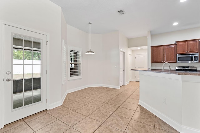 703 Elkhorn Fern Ln, Deland, FL 32720 - kitchen with appliances with stainless steel finishes, light tile patterned floors, recessed lighting, decorative light fixtures, and baseboards