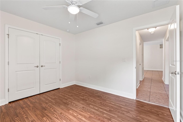 703 Elkhorn Fern Ln, Deland, FL 32720 - unfurnished bedroom with wood finished floors, baseboards, a closet, and ceiling fan