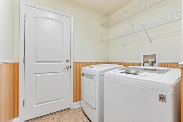 703 Elkhorn Fern Ln, Deland, FL 32720 - laundry room featuring a wainscoted wall, washer and dryer, wood walls, and light tile patterned floors