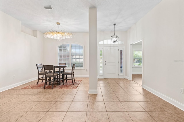 703 Elkhorn Fern Ln, Deland, FL 32720 - foyer with a chandelier, light tile patterned floors, a textured ceiling, and baseboards