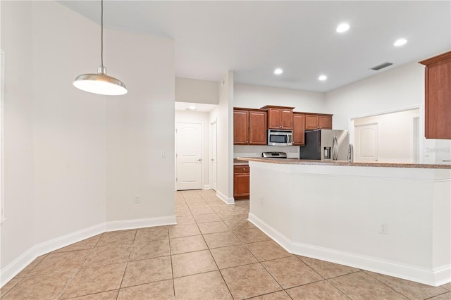 703 Elkhorn Fern Ln, Deland, FL 32720 - kitchen featuring appliances with stainless steel finishes, light tile patterned floors, brown cabinetry, baseboards, and light countertops