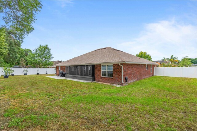 703 Elkhorn Fern Ln, Deland, FL 32720 - back of house with a sunroom, brick siding, roof with shingles, and a patio