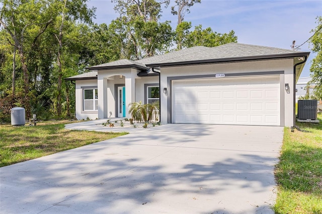 1738 Palm Rd, Ormond Beach, FL 32174 - view of front facade with stucco siding, central AC unit, driveway, an attached garage, and a shingled roof