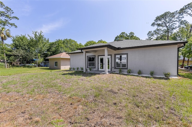 1738 Palm Rd, Ormond Beach, FL 32174 - back of property with a yard, stucco siding, and french doors