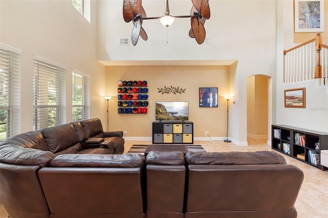 123 Ivydale Manor Dr, Deland, FL 32724 - living room featuring a towering ceiling, arched walkways, healthy amount of natural light, a ceiling fan, and tile patterned flooring