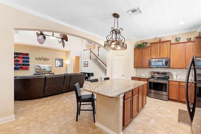 123 Ivydale Manor Dr, Deland, FL 32724 - kitchen featuring stainless steel appliances, arched walkways, open floor plan, backsplash, and a center island