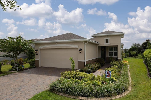view of front of house featuring stucco siding, decorative driveway, and an attached garage