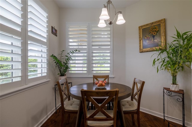dining space with dark wood finished floors, baseboards, and a chandelier