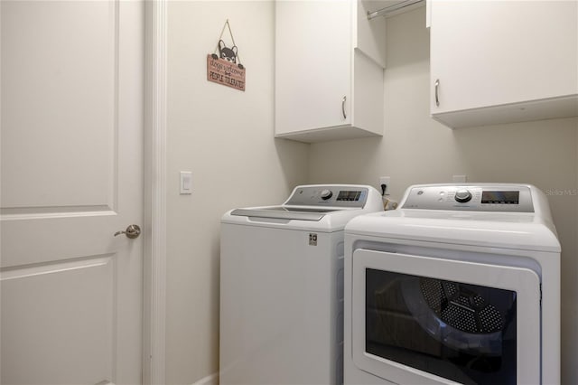 laundry area featuring washing machine and dryer and cabinet space