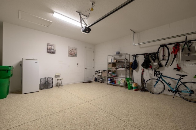 garage featuring a garage door opener and concrete block wall