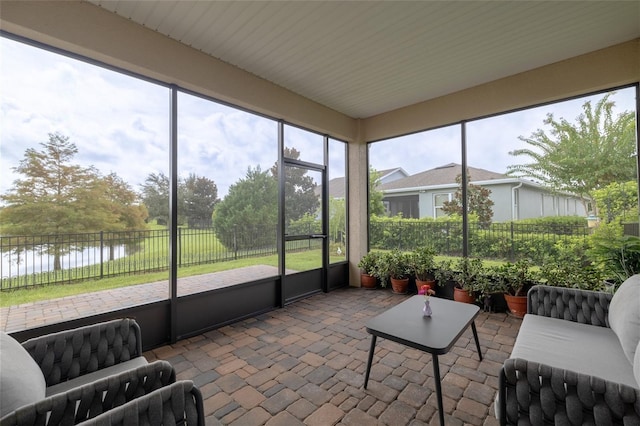 sunroom / solarium featuring a water view