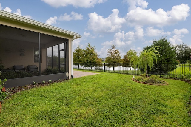 view of yard featuring a water view and a sunroom