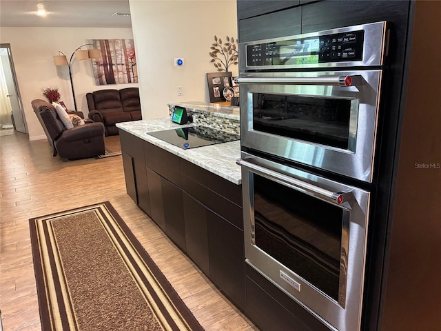 516 Hickorywood Ave, Altamonte Springs, FL 32714 - kitchen with double oven, black electric stovetop, light wood-style floors, modern cabinets, and dark cabinets