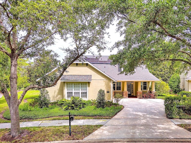 view of front of property featuring stucco siding, covered porch, and driveway