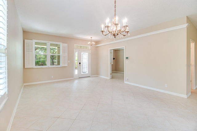 unfurnished room featuring a chandelier, light tile patterned floors, and baseboards