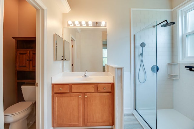 full bathroom featuring tiled shower, toilet, and vanity