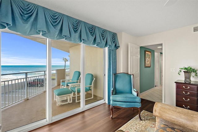 2967 S Atlantic Ave Unit 202, Daytona Beach Shores, FL 32118 - living area featuring wood finished floors, view of water and beach, and baseboards