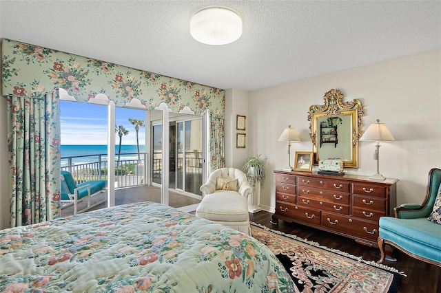 2967 S Atlantic Ave Unit 202, Daytona Beach Shores, FL 32118 - bedroom with access to exterior, wood finished floors, a water view, a textured ceiling, and baseboards