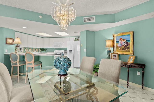 2967 S Atlantic Ave Unit 202, Daytona Beach Shores, FL 32118 - dining area with light tile patterned floors, baseboards, a textured ceiling, a chandelier, and recessed lighting