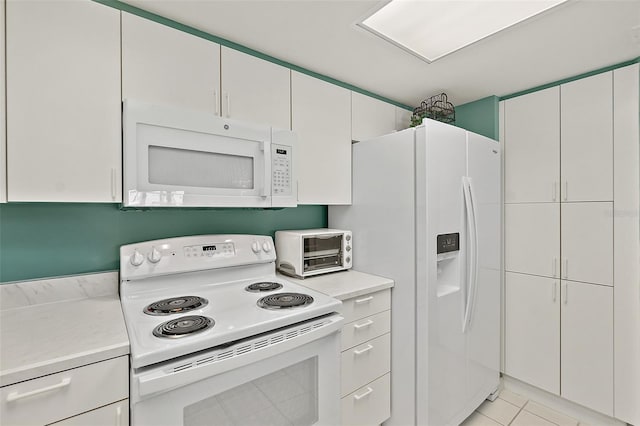 2967 S Atlantic Ave Unit 202, Daytona Beach Shores, FL 32118 - kitchen with white appliances, light countertops, light tile patterned flooring, and white cabinetry
