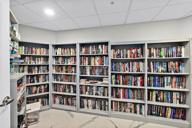 2967 S Atlantic Ave Unit 202, Daytona Beach Shores, FL 32118 - miscellaneous room featuring wall of books, marble finish flooring, and a drop ceiling