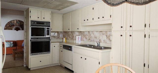 kitchen featuring a sink, white dishwasher, open shelves, tasteful backsplash, and light countertops