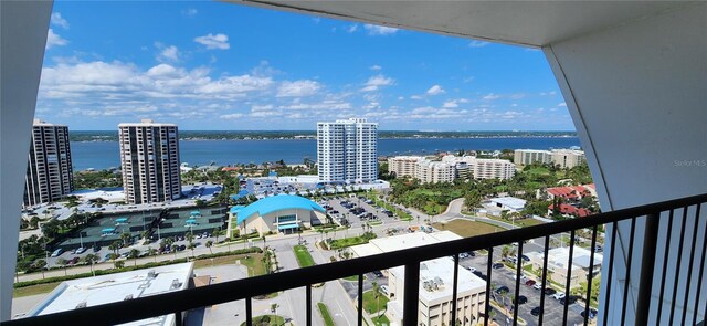 balcony with a water view, a city view, and central AC
