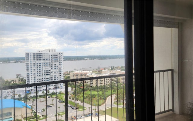 balcony with a water view and a view of city