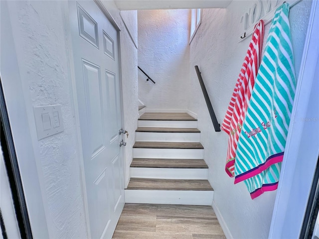 3112 S Atlantic Ave, Daytona Beach, FL 32118 - stairs with a textured wall, wood finished floors, and baseboards
