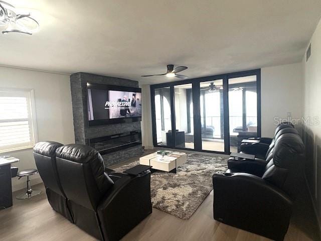 living area with light wood finished floors, a ceiling fan, and plenty of natural light