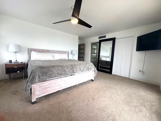 carpeted bedroom with ceiling fan and baseboards