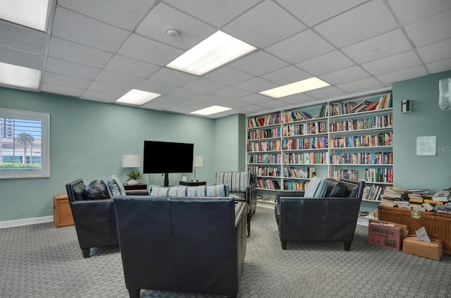 carpeted office with a drop ceiling and baseboards