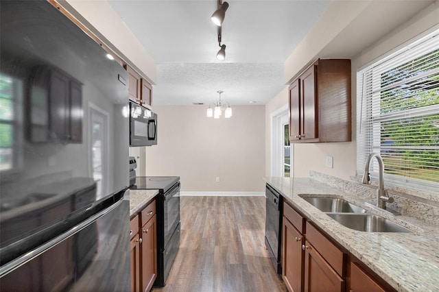 541 Northwestern Ave, Altamonte Springs, FL 32714 - kitchen featuring black appliances, a sink, wood finished floors, a chandelier, and light stone countertops