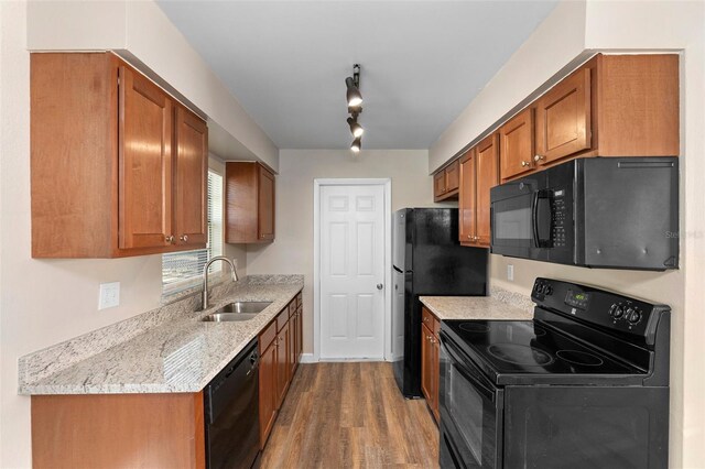 541 Northwestern Ave, Altamonte Springs, FL 32714 - kitchen featuring black appliances, a sink, wood finished floors, brown cabinets, and light stone counters