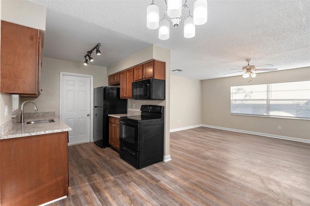 541 Northwestern Ave, Altamonte Springs, FL 32714 - kitchen featuring black appliances, a sink, brown cabinetry, a textured ceiling, and dark wood-type flooring