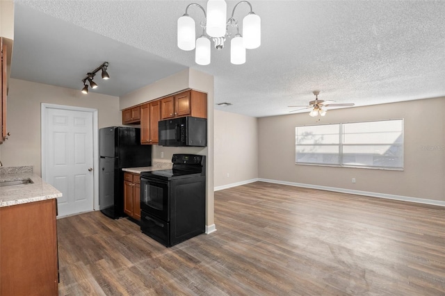 541 Northwestern Ave, Altamonte Springs, FL 32714 - kitchen with black appliances, brown cabinetry, a textured ceiling, a sink, and track lighting