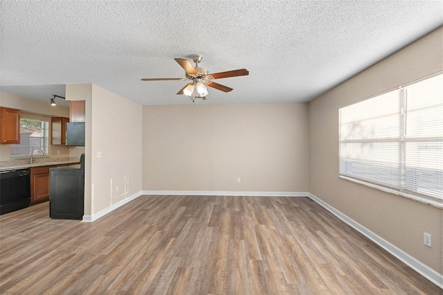 541 Northwestern Ave, Altamonte Springs, FL 32714 - unfurnished living room featuring light wood-style floors, ceiling fan, a textured ceiling, baseboards, and a sink