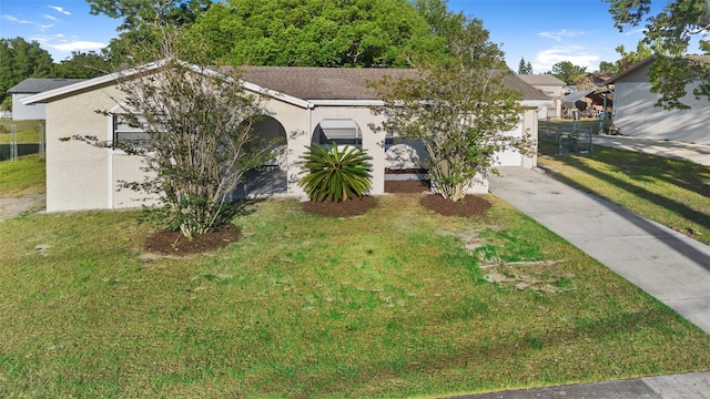541 Northwestern Ave, Altamonte Springs, FL 32714 - obstructed view of property featuring stucco siding, a front yard, a garage, and concrete driveway