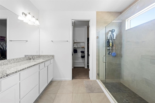 518 Briarbrook Way, Deland, FL 32724 - bathroom featuring a shower stall, a spacious closet, vanity, tile patterned flooring, and baseboards