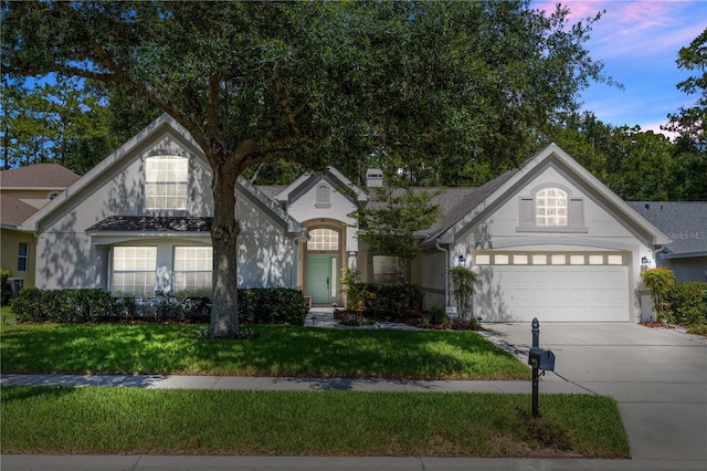 1412 Bent Oaks Blvd, Deland, FL 32724 - view of front facade featuring driveway, a garage, a lawn, and stucco siding