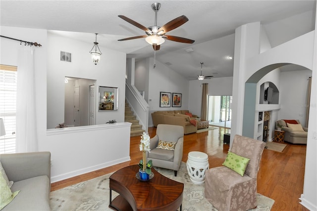 1412 Bent Oaks Blvd, Deland, FL 32724 - living area with a ceiling fan, wood finished floors, arched walkways, high vaulted ceiling, and stairway