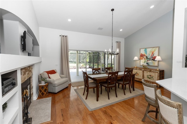 1412 Bent Oaks Blvd, Deland, FL 32724 - dining room featuring light wood-type flooring, vaulted ceiling, a fireplace, recessed lighting, and a chandelier