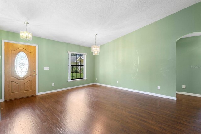 1120 W Glen Falls Rd, Deland, FL 32720 - entrance foyer featuring a chandelier, healthy amount of natural light, arched walkways, wood-type flooring, and a textured ceiling