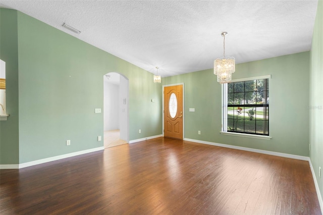 1120 W Glen Falls Rd, Deland, FL 32720 - entrance foyer featuring arched walkways, wood finished floors, a chandelier, a textured ceiling, and baseboards