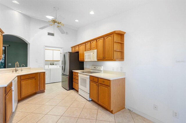 1120 W Glen Falls Rd, Deland, FL 32720 - kitchen with white appliances, independent washer and dryer, ceiling fan, light tile patterned floors, and arched walkways