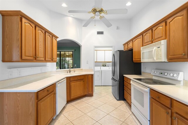 1120 W Glen Falls Rd, Deland, FL 32720 - kitchen featuring white appliances, washer and clothes dryer, a sink, a ceiling fan, and arched walkways