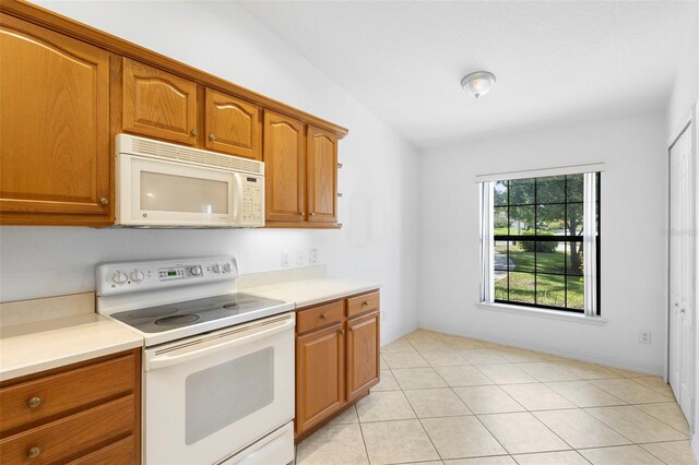 1120 W Glen Falls Rd, Deland, FL 32720 - kitchen with white appliances, brown cabinetry, light countertops, and light tile patterned floors