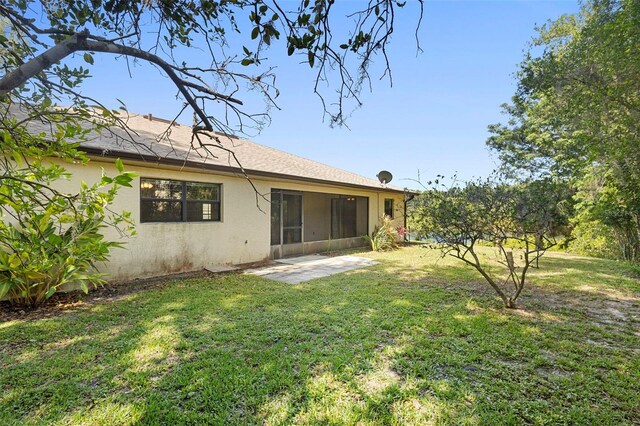 1120 W Glen Falls Rd, Deland, FL 32720 - back of house featuring stucco siding, a yard, and a sunroom